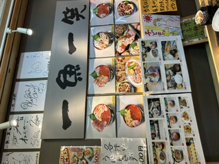 一魚一笑のお店の外、芸能人のサインとメニュー