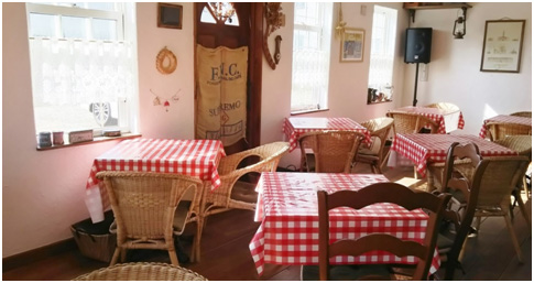 マヤカフェ店内の様子｜赤いテーブルクロスと白い塗り壁のコントラストが温か