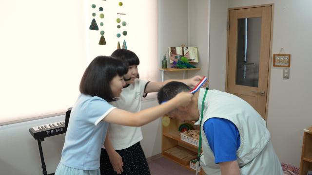 金森巴菜さんと比菜さんから金メダルを贈られる長谷部 希晶さん