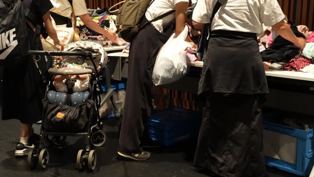 おさがりくるりん会場で服を交換する人々