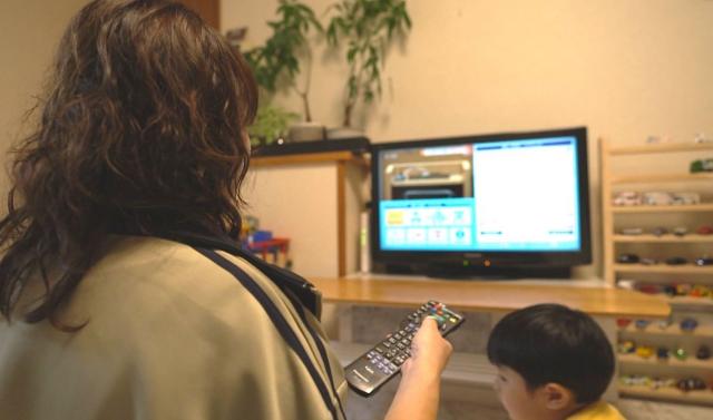 テレビ画面を操作する親子